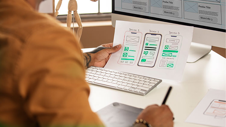 Man studying a printed mockup of a mobile app.